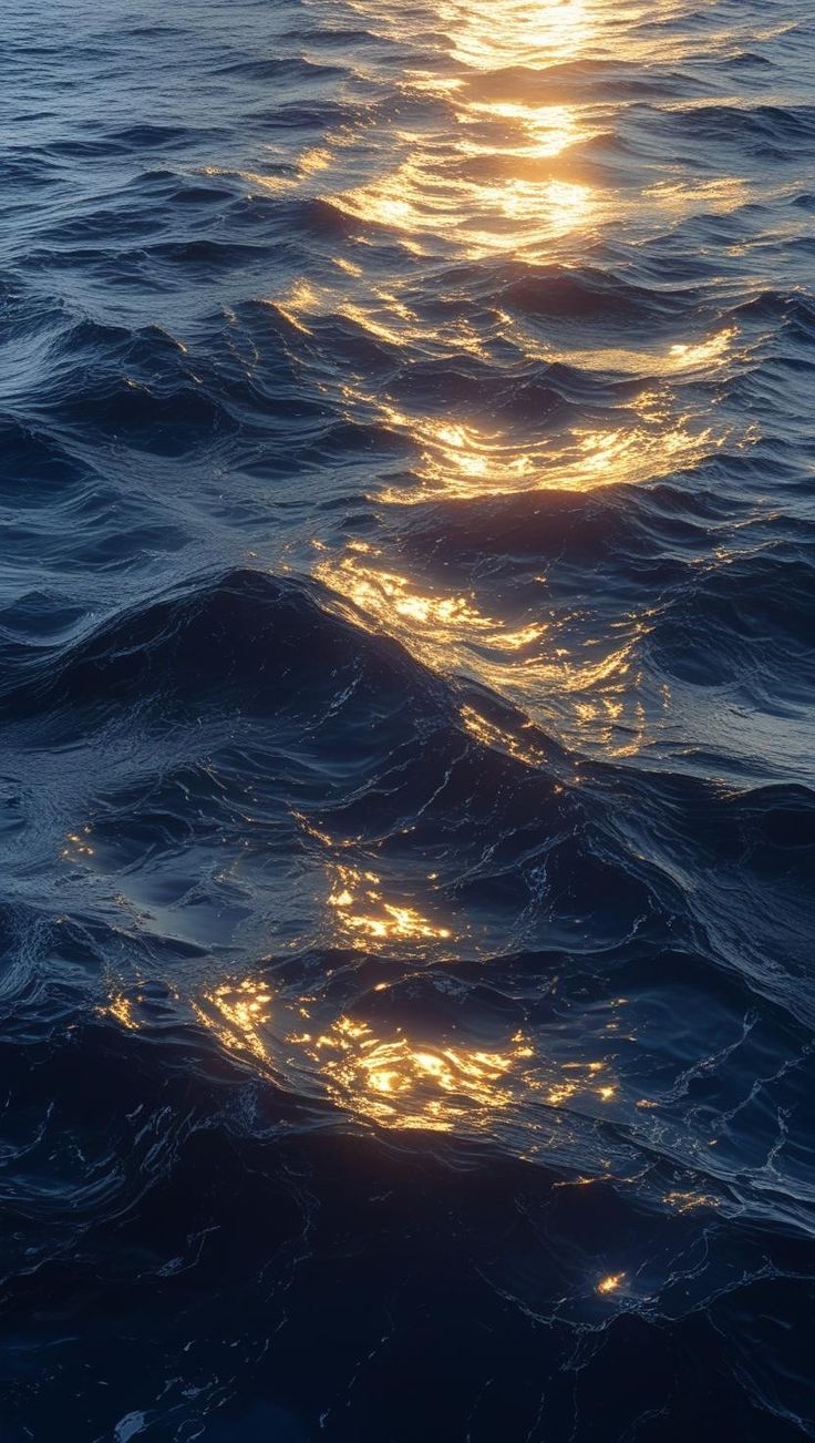 Ondas escuras do mar refletindo a luz dourada do pôr do sol