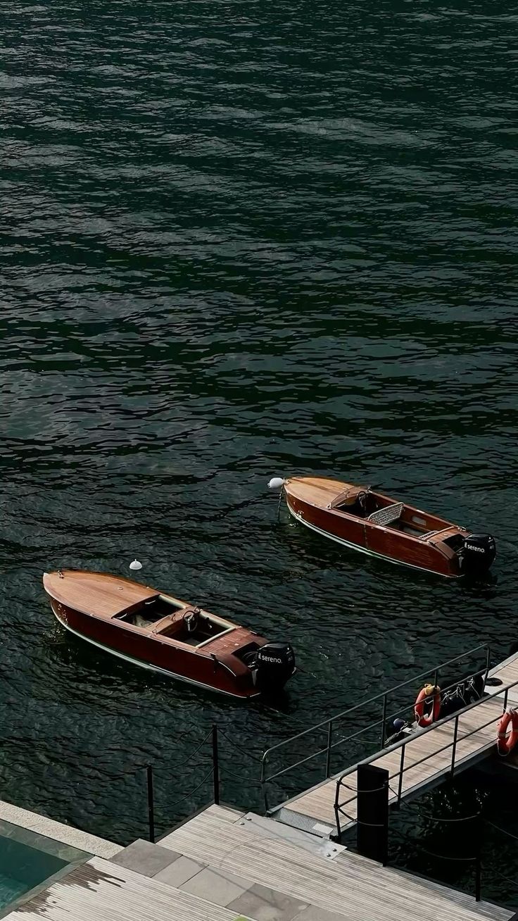 Dois barcos de madeira ancorados perto de um píer