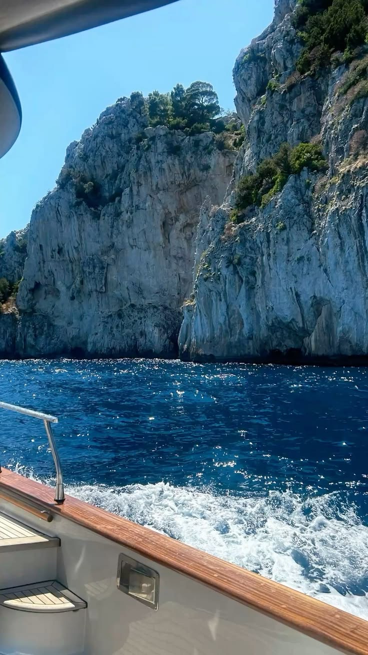 Falésias vistas de um barco em movimento no mar azul