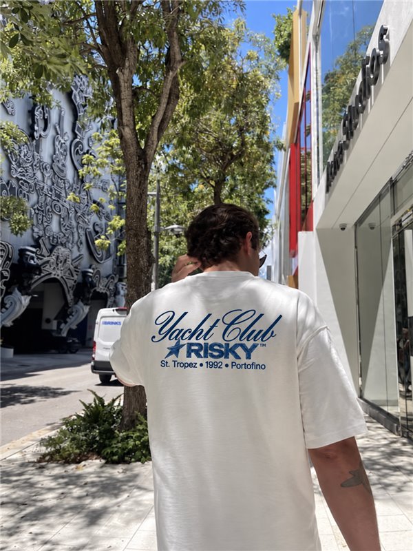 Rapaz de costas na rua vestindo a camiseta branca oversized Yacht Club